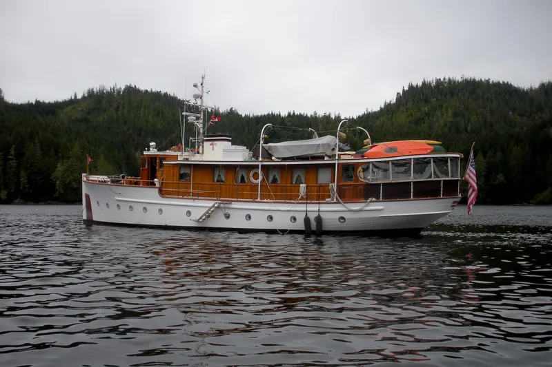 Slide: The Image of 1929 HOFFAR-BEECHING Fantail Yacht on a serene lake with forested hills. - 14