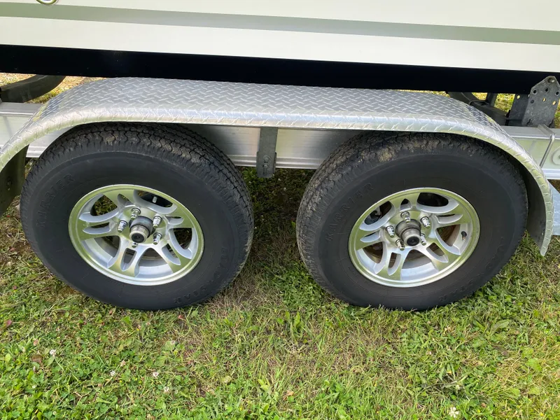 Slide: The Image of Trailer wheels of a 2020 Sea Fox Commander 248 boat on grass. - 28