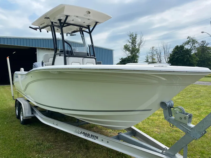 Slide: The Image of 2020 Sea Fox Commander 248 boat on trailer, parked on grass near a blue building. - 3