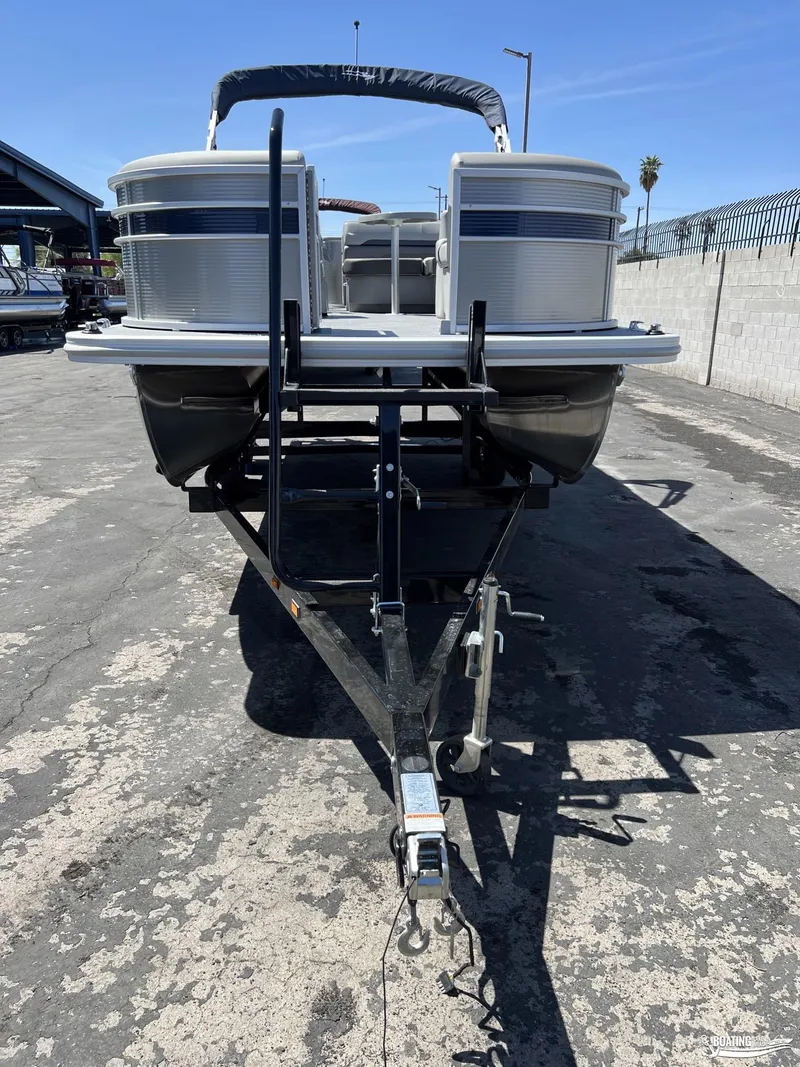 Slide: The Image of 2022 Bennington 21 SXRF pontoon boat on trailer, parked outdoors. - 2