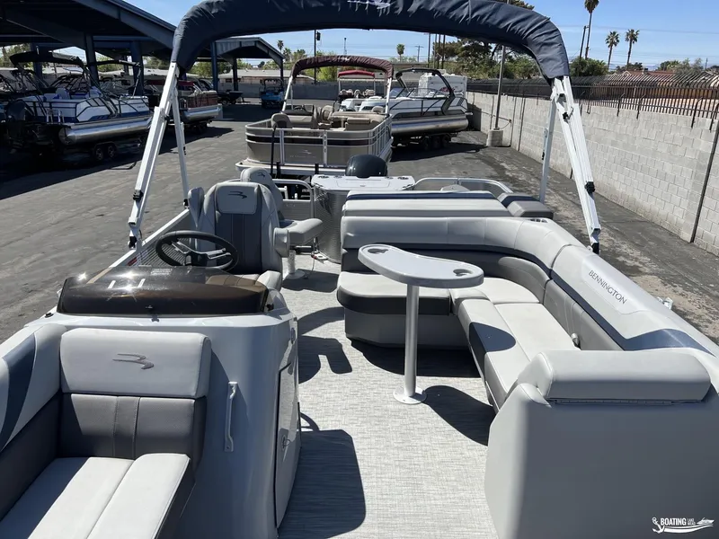 Slide: The Image of 2022 Bennington 21 SXRF pontoon boat with spacious seating and canopy in a marina setting. - 3