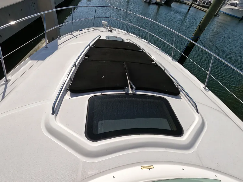 Slide: The Image of 2007 Sea Ray 44 Sundancer yacht deck with sunpads and railing, docked at marina. - 12