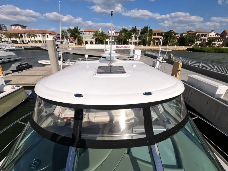 Slide: The Image of 2007 Sea Ray 44 Sundancer yacht docked at a marina with waterfront homes. - 13