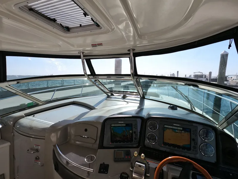 Slide: The Image of 2007 Sea Ray 44 Sundancer helm with navigation screens and marina view. - 29