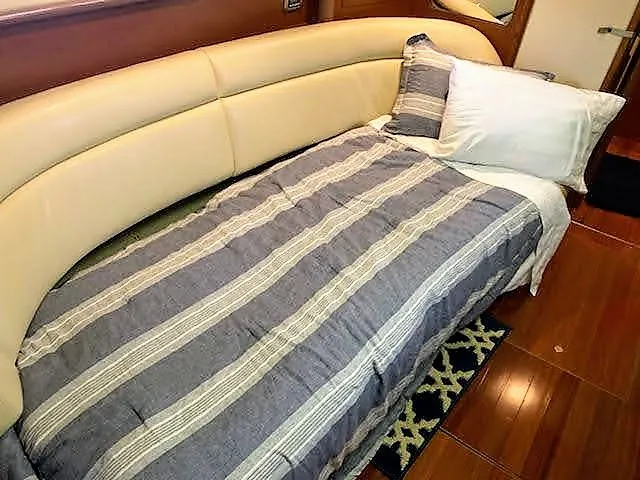 Slide: The Image of Interior cabin of 2007 Sea Ray 44 Sundancer with bed and striped bedding. - 35