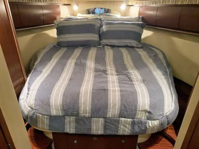 Slide: The Image of 2007 Sea Ray 44 Sundancer master bedroom with striped bedding. - 44