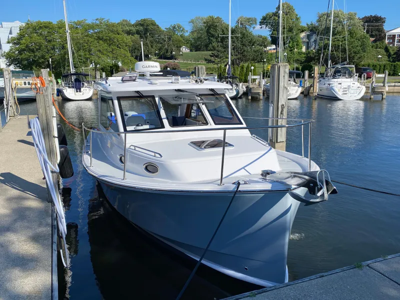 Slide: The Image of 2023 True North 34 Outboard Express docked at a marina, surrounded by sailboats. - 1