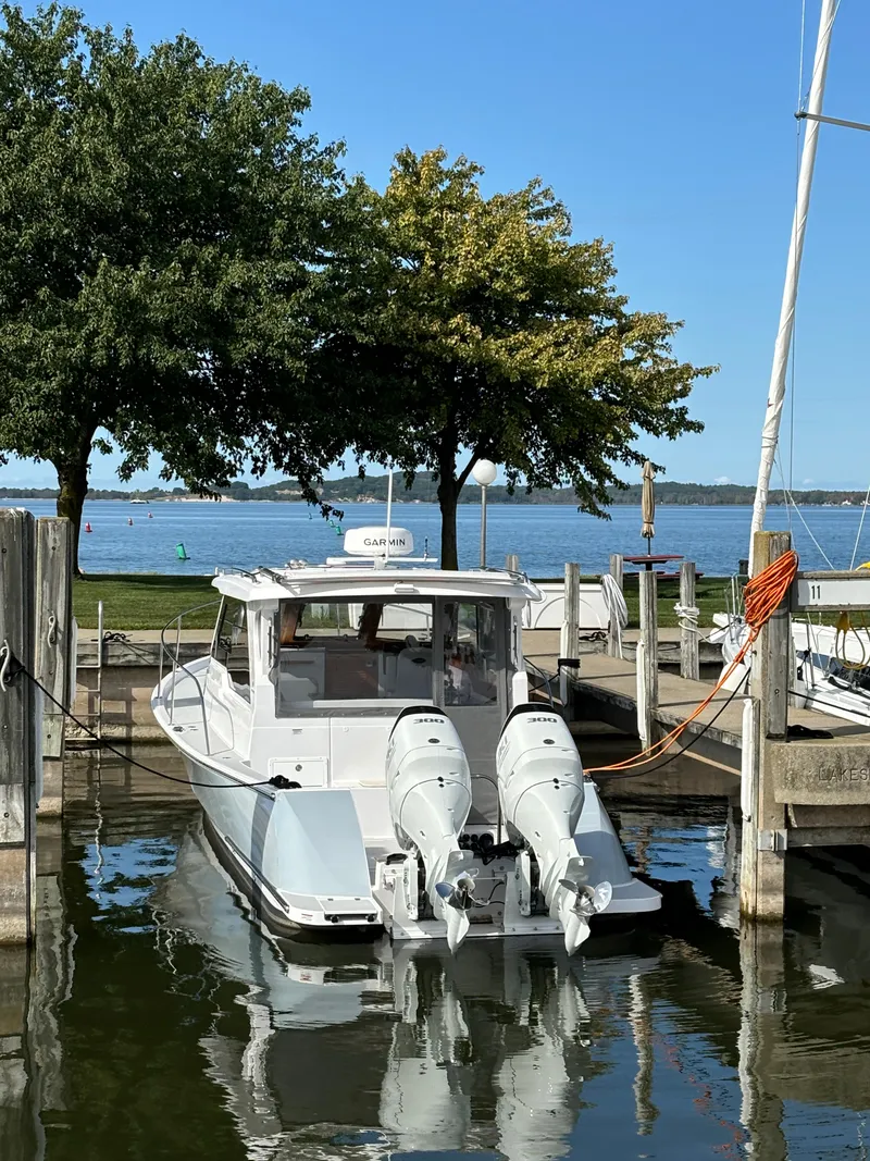 Slide: The Image of 2023 True North 34 Outboard Express docked by a scenic lakeside. - 10
