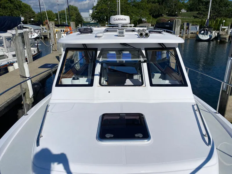 Slide: The Image of 2023 True North 34 Outboard Express docked at marina, featuring Garmin equipment. - 16