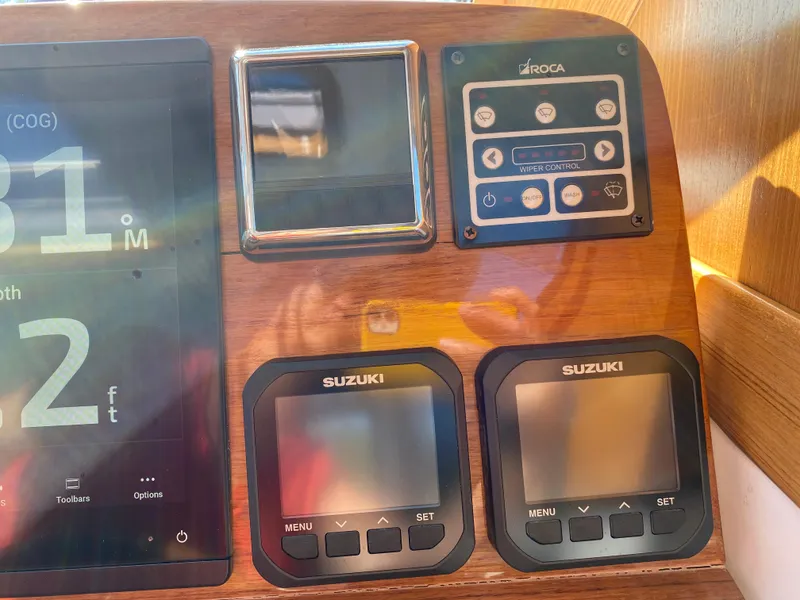 Slide: The Image of Control panel of 2023 True North 34 Outboard Express with Suzuki displays and wiper controls. - 25