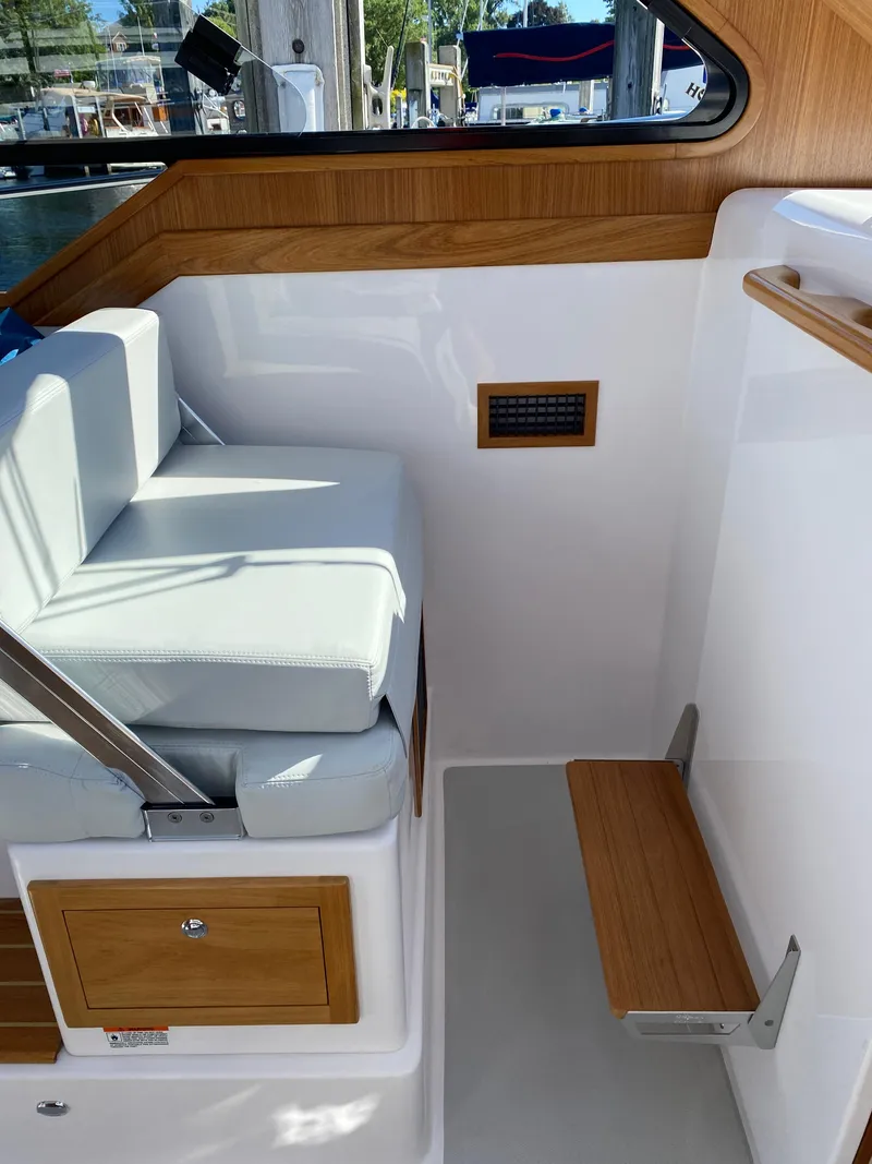Slide: The Image of Interior of 2023 True North 34 Outboard Express boat with wooden accents and cushioned seating. - 30