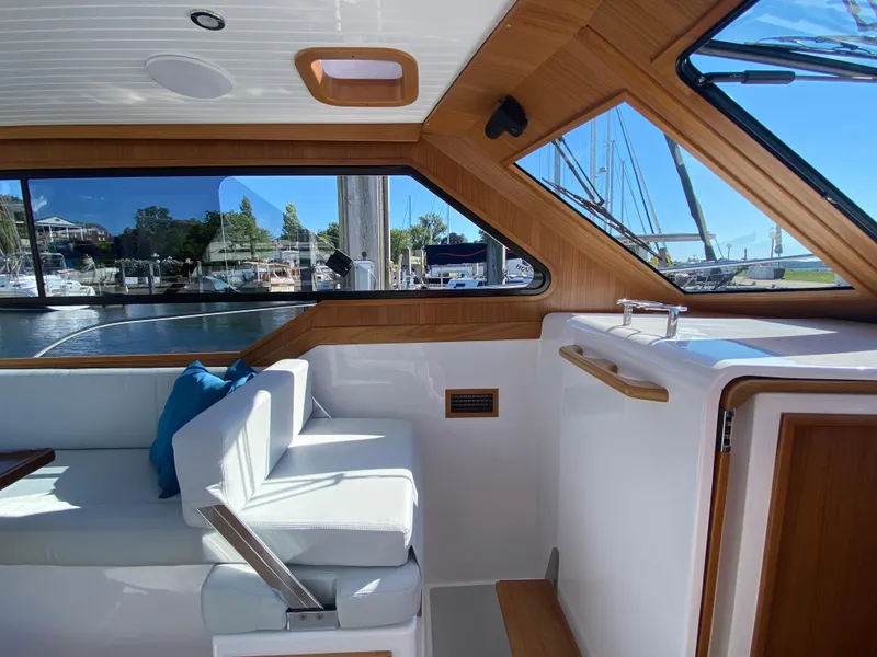 Slide: The Image of 2023 True North 34 Outboard Express interior with white seating and wooden accents. - 31