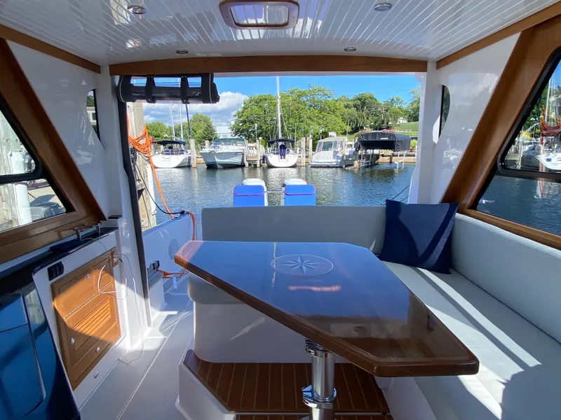 Slide: The Image of Interior of 2023 True North 34 Outboard Express yacht with dock view. - 34