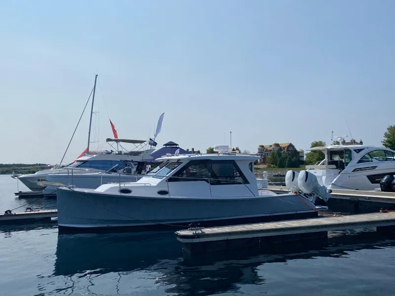 Slide: The Image of 2023 True North 34 Outboard Express docked at marina, clear sky background. - 7