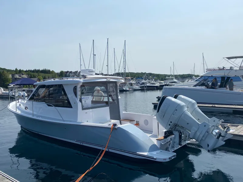 Slide: The Image of 2023 True North 34 Outboard Express boat docked in marina, surrounded by other vessels. - 8
