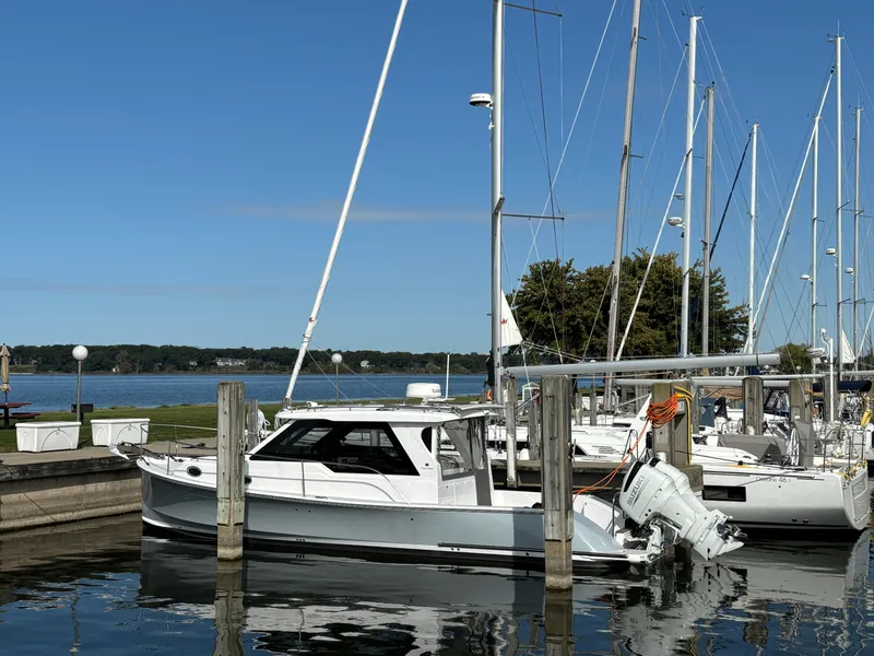 Slide: The Image of 2023 True North 34 Outboard Express docked at marina with sailboats. - 9