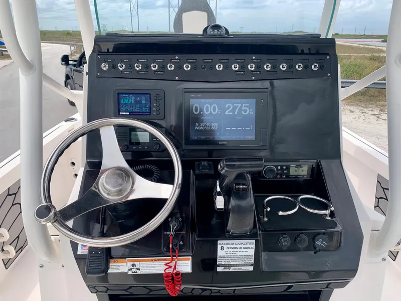 Slide: The Image of 2019 Wellcraft 241 Bay boat dashboard with steering wheel and electronic controls. - 16