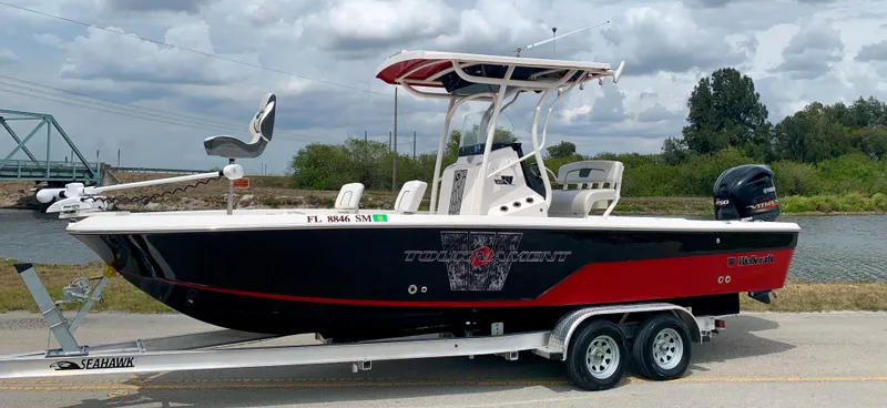 Slide: The Image of 2019 Wellcraft 241 Bay boat on trailer by a river. - 2