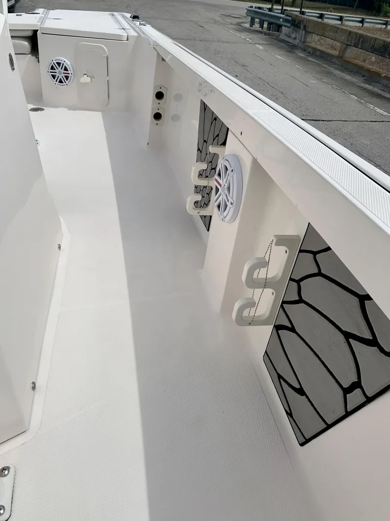 Slide: The Image of 2019 Wellcraft 241 Bay boat interior with rod holders and speakers. - 24