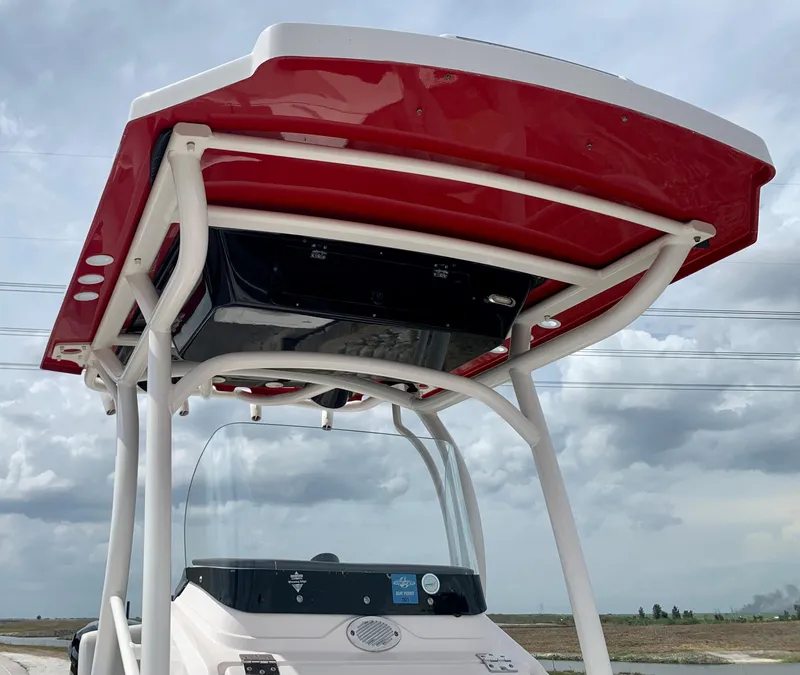 Slide: The Image of 2019 Wellcraft 241 Bay boat with red T-top against cloudy sky. - 35