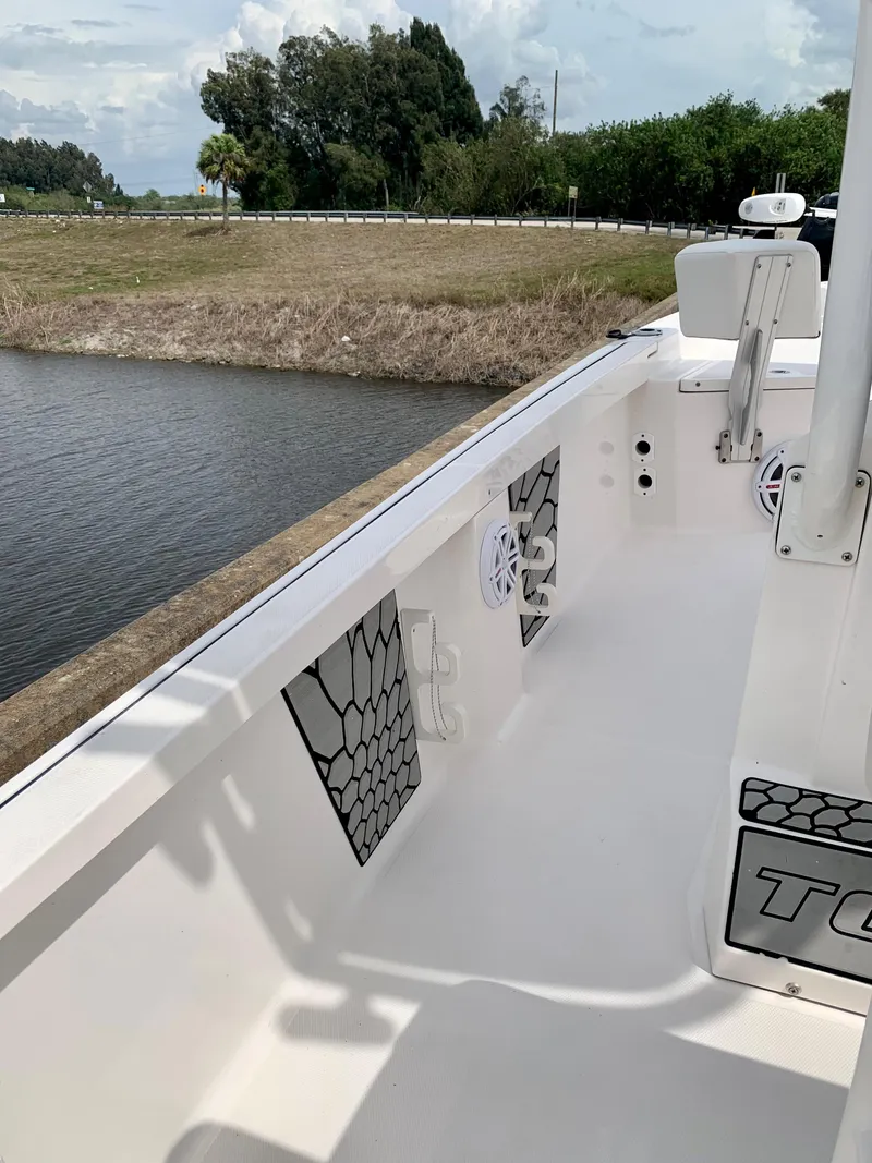 Slide: The Image of 2019 Wellcraft 241 Bay boat interior near water and grassy shore. - 36