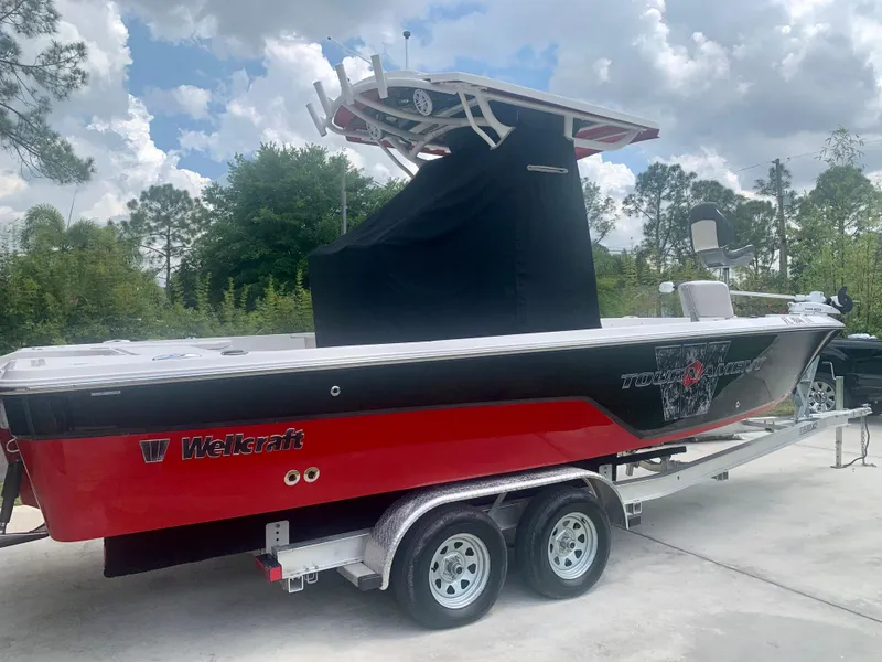 Slide: The Image of 2019 Wellcraft 241 Bay boat on a trailer, red and black exterior. - 6