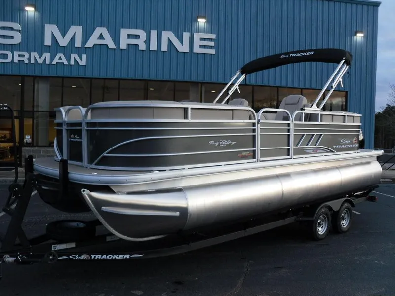 Slide: The Image of 2023 Sun Tracker PARTY BARGE® 22 XP3 pontoon boat on trailer outside dealership. - 3