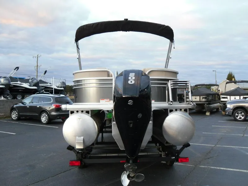Slide: The Image of 2023 Sun Tracker PARTY BARGE® 22 XP3 pontoon boat with outboard motor in a parking lot. - 9