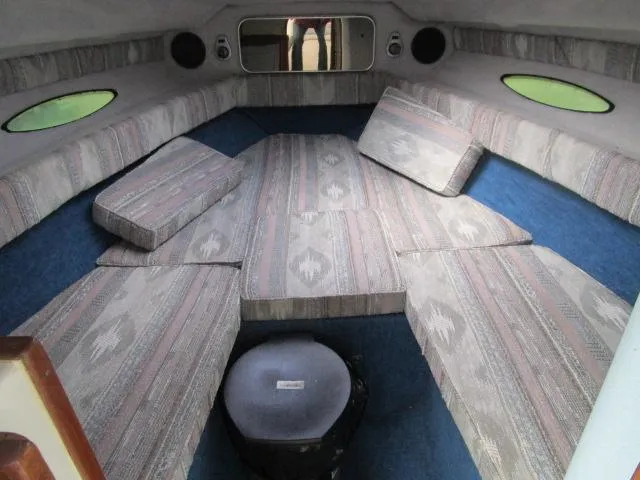 Slide: The Image of Interior cabin of a 1989 Sea Ray 230 Cuddy boat with cushioned seating. - 11