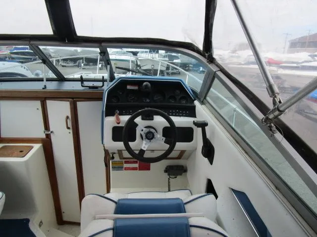 Slide: The Image of 1989 Sea Ray 230 Cuddy boat cockpit with steering wheel and instrument panel. - 6