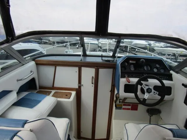 Slide: The Image of 1989 Sea Ray 230 Cuddy boat cockpit with steering wheel and seating. - 7