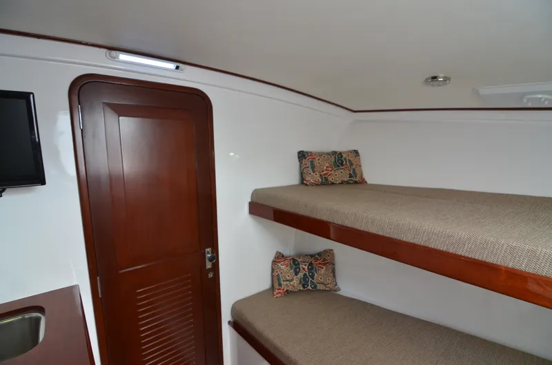 Slide: The Image of Interior of 1993 Gamefisherman Open with bunk beds and wooden door. - 18