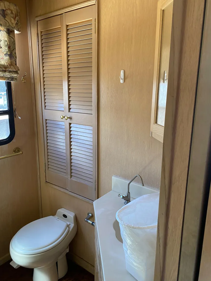 Slide: The Image of 2001 Stardust Cruisers bathroom with toilet, sink, and wooden cabinet. - 14