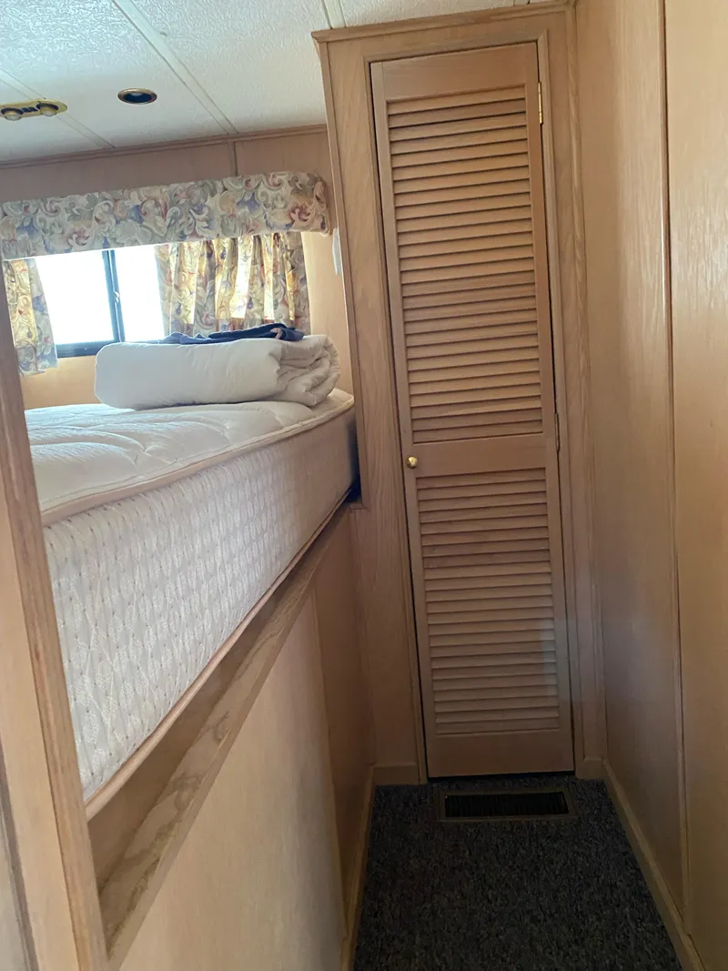 Slide: The Image of Narrow hallway in 2001 Stardust Cruisers houseboat with bed and closet. - 15