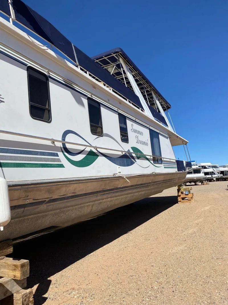 The Image of 2001 Stardust Cruisers Summer Dreamin' houseboat on dry land, clear blue sky background. - 2