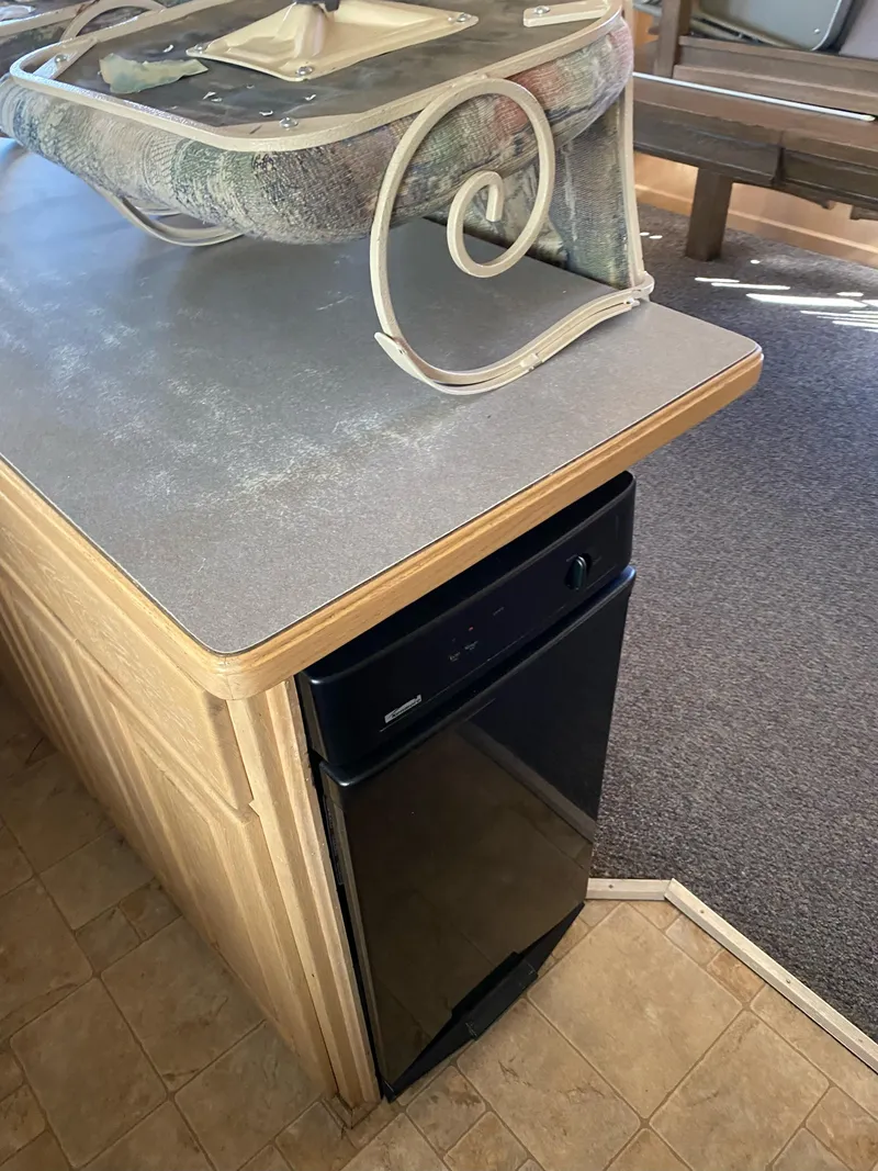 Slide: The Image of 2001 Stardust Cruisers kitchen area with countertop and black dishwasher. - 21