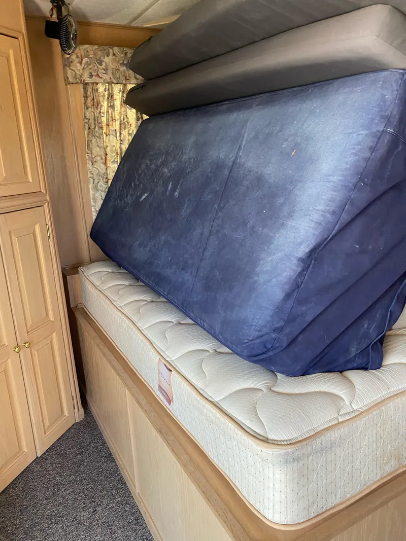 Slide: The Image of Interior of 2001 Stardust Cruisers, showing stacked mattresses and wooden cabinetry. - 8