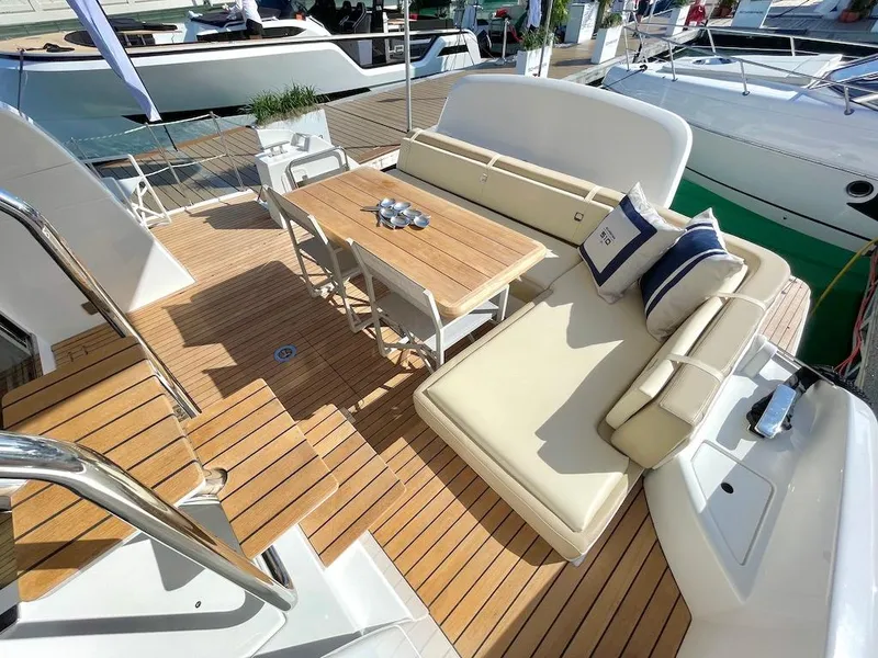 Slide: The Image of Luxurious 2025 Schaefer 510 GT yacht deck with elegant seating and wooden table. - 11
