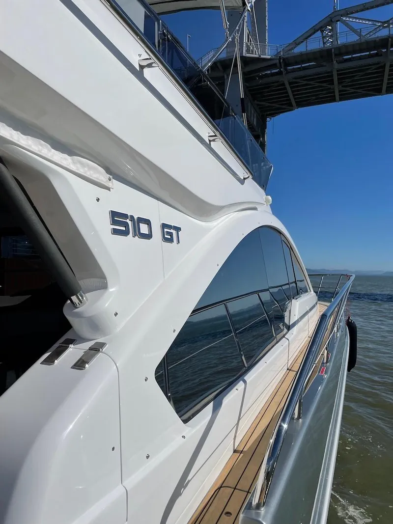 Slide: The Image of Schaefer 510 GT yacht cruising under a bridge, 2025 model. - 34