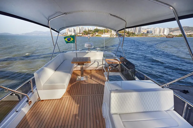 Slide: The Image of Luxurious 2025 Schaefer 510 GT yacht with spacious deck, Brazilian flag, and scenic coastal view. - 36