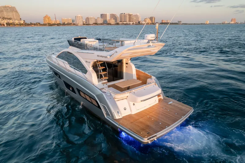 Slide: The Image of 2025 Schaefer 510 GT yacht cruising on ocean near city skyline at sunset. - 4