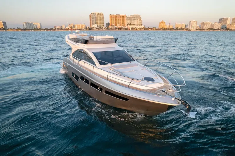 Slide: The Image of 2025 Schaefer 510 GT yacht cruising on open water near a city skyline. - 9