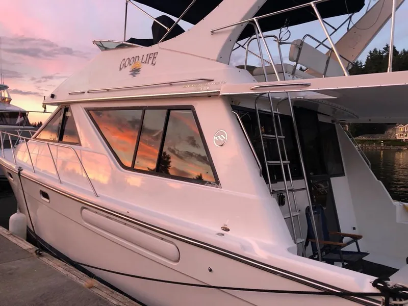 Slide: The Image of 2002 Bayliner 3988 Command Bridge Motoryacht docked at sunset, reflecting vibrant sky colors. - 2
