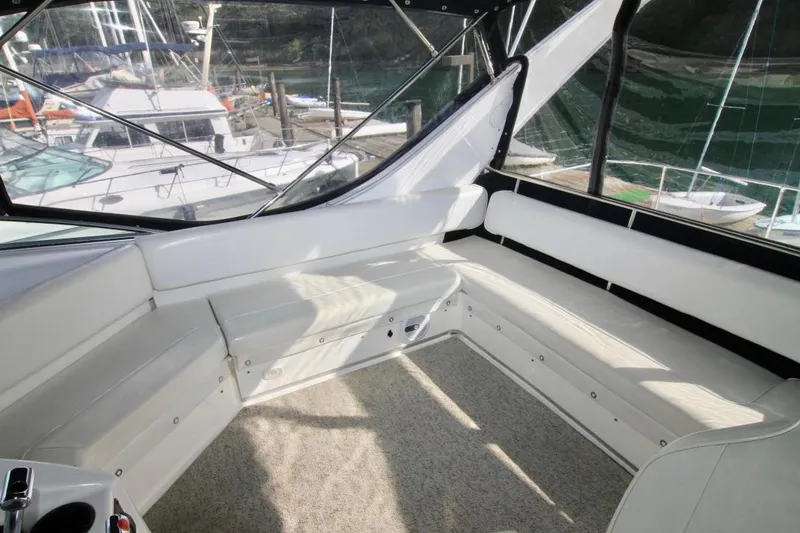Slide: The Image of 2002 Bayliner 3988 Command Bridge Motoryacht interior with white seating and marina view. - 26