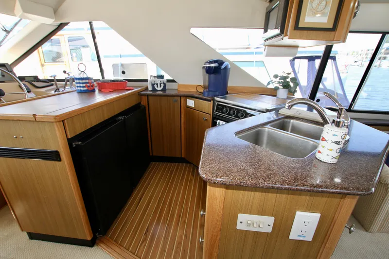 Slide: The Image of 2002 Bayliner 3988 Command Bridge Motoryacht kitchen with wood cabinetry and modern appliances. - 36