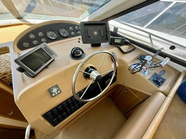 Slide: The Image of 2002 Bayliner 3988 Command Bridge Motoryacht helm with steering wheel and navigation instruments. - 44