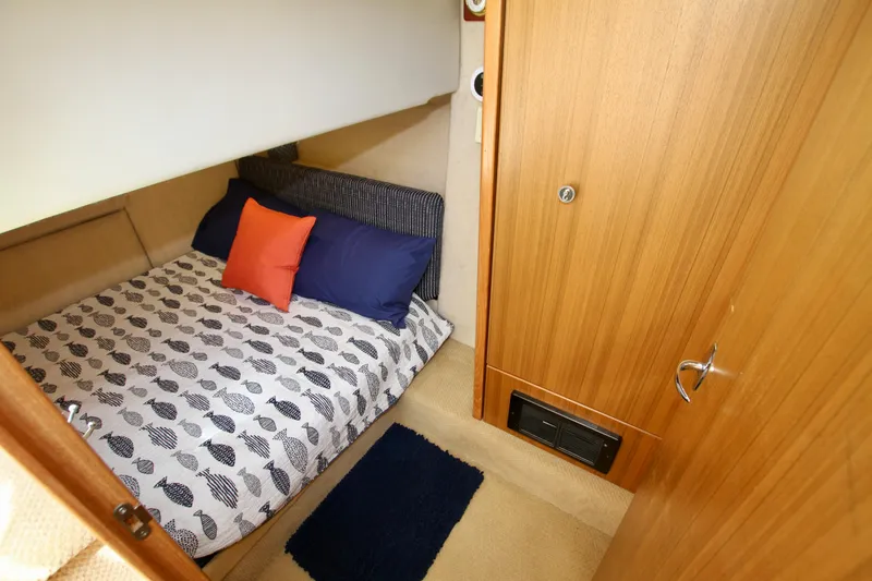 Slide: The Image of Cozy bedroom in 2002 Bayliner 3988 Command Bridge Motoryacht with patterned bedding and wooden accents. - 54