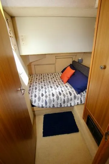 Slide: The Image of 2002 Bayliner 3988 Command Bridge Motoryacht cabin with cozy bed and colorful pillows. - 57