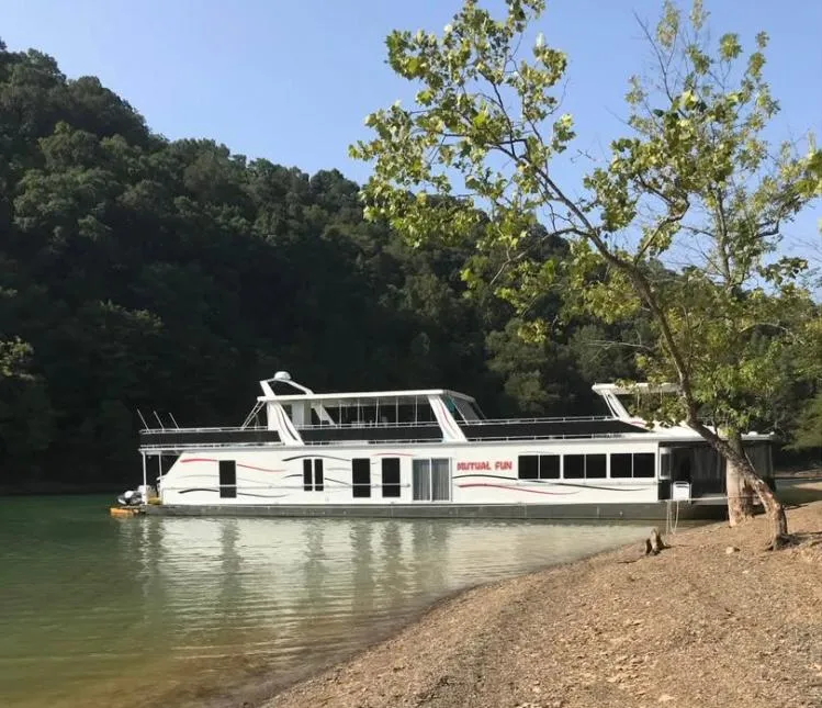 The Image of Fantasy 2006 houseboat on a serene lake, surrounded by lush greenery. - 0