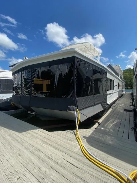 Slide: The Image of Fantasy 2006 houseboat docked under a clear blue sky with fluffy clouds. - 1